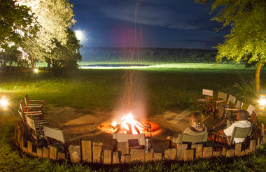 Boma & campfire overlooking floodlit waterhole