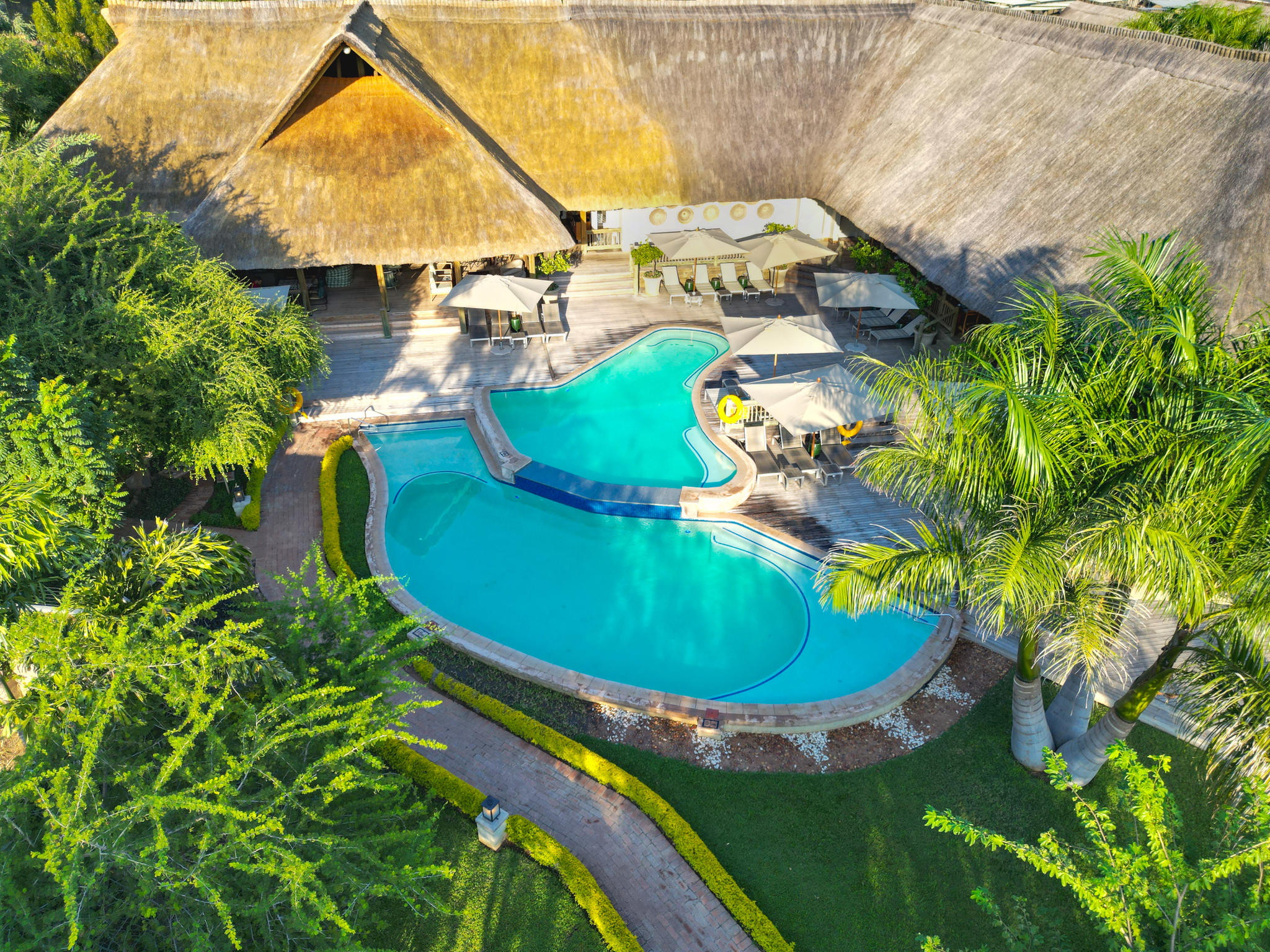 Pool and thatched lodge buildings at Shearwater Explorers Village