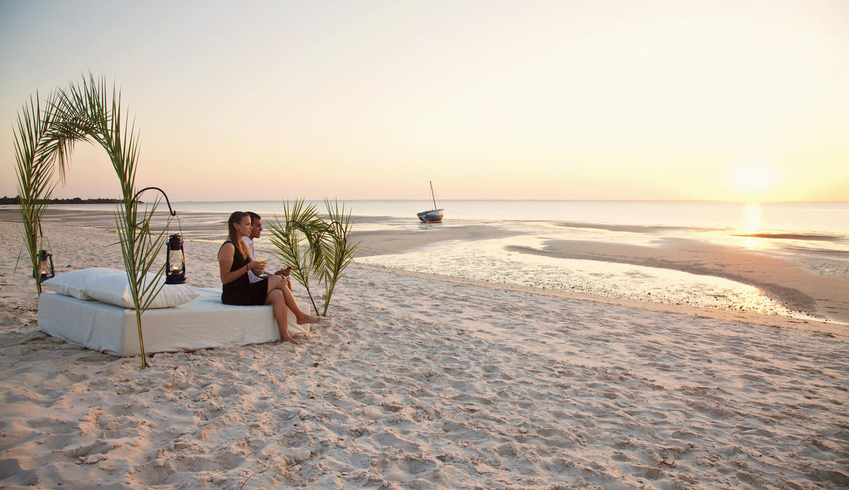 Couple having sundowners with beach setup