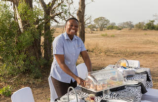 Serving breakfast with a smile in the bush