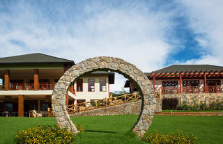 The iconic Arc on a beautiful garden in front of the main bar and coffee bar (downstairs on the left building) and the restaurant (the right building.