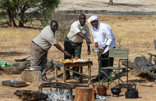 Camp staff preparing a hearty meal