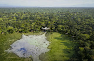 Render: Overhead view of Chicari camp between the trees, overlooking the pan
