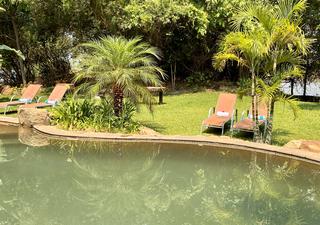 Der natürliche Pool der Lodge bietet Flussblick und liegt inmitten eines üppigen Gartens.