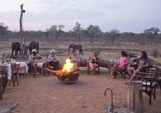 Sundowners around the camp fire with the ele&#039;s at the waterhole