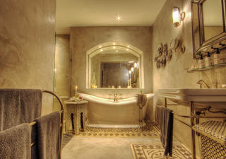 Innenansicht des Standardzimmers und der Anzugbäder der Chobe Game Lodge mit Doppelwaschbecken, Badewanne und separater Dusche