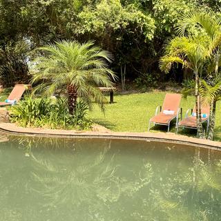 Der natürliche Pool der Lodge bietet Flussblick und liegt inmitten eines üppigen Gartens.