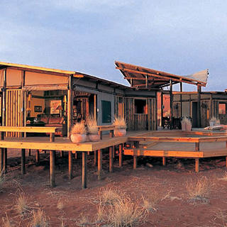 Eine Kombination aus Holzkonstruktionen und Leinwandjalousien, die sich bis zur Wüste hinüber öffnen