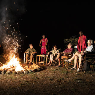 Gäste genießen das Feuer am Abend und Geräusche des Busches