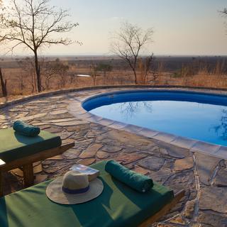 Genießen Sie ein abkühlendes Bad im Pool und beobachten Sie, wie die Tierwelt zum Trinken in das Wasserloch Mwanamboga kommt
