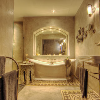 Innenansicht des Standardzimmers und der Anzugbäder der Chobe Game Lodge mit Doppelwaschbecken, Badewanne und separater Dusche