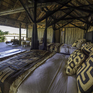 Betten unter schwarzen Moskitonetzen mit schöner Aussicht