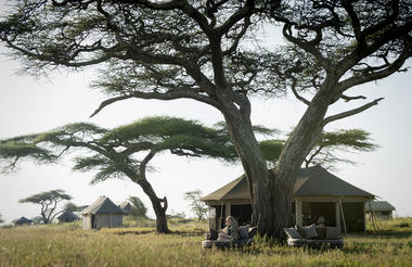 Namiri Plains - guests relaxing outside lounge area tent