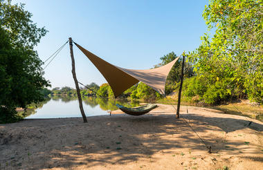 Hammock on the beach with view onto the lagoon.