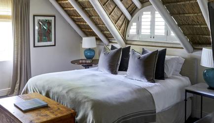 Bed under charming thatched roof