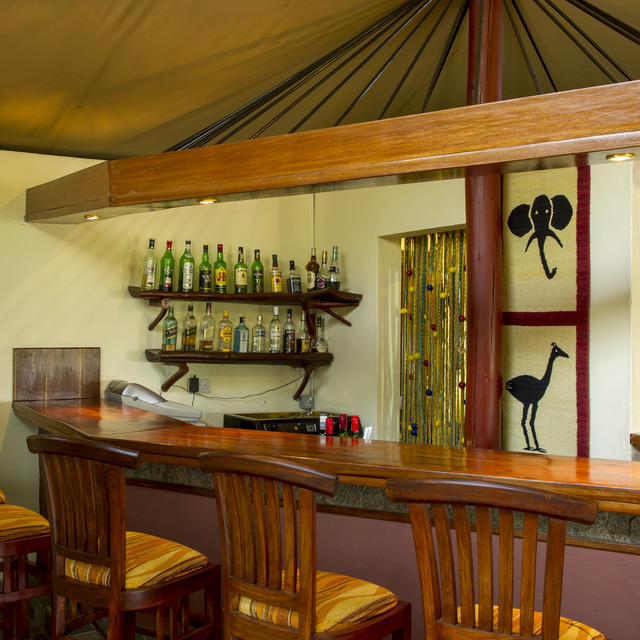 Diese stilvolle Bar befindet sich im zentralen Loungebereich des Camps und ist ein willkommener Ort für einen Cocktail mit Freunden nach einem erfolgreichen Safari-Tag.