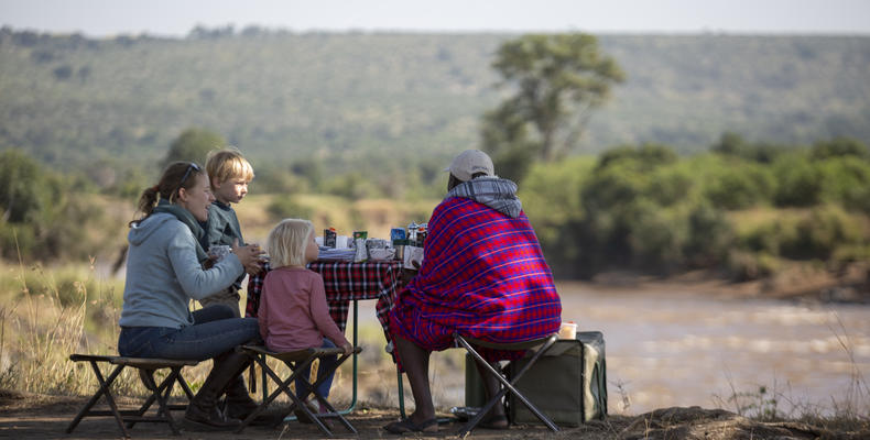 Guests enjoying a picnic breakfast by the Mara River