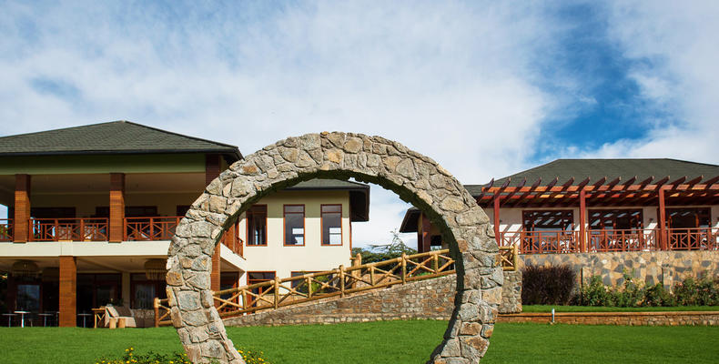 The iconic Arc on a beautiful garden in front of the main bar and coffee bar (downstairs on the left building) and the restaurant (the right building.