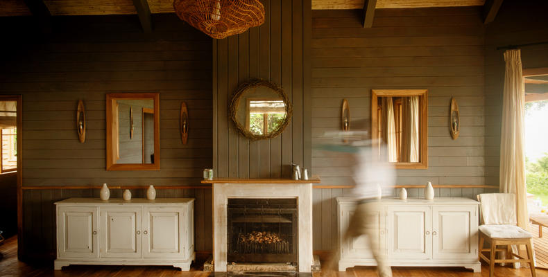  A waiter walks past the warming fire in the dining area