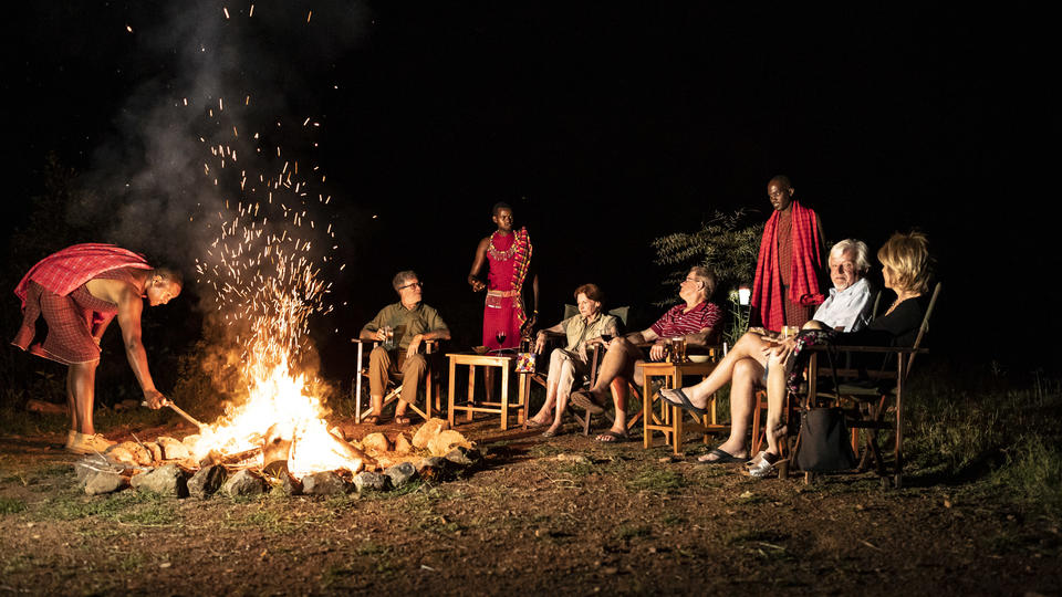 Gäste genießen das Feuer am Abend und Geräusche des Busches