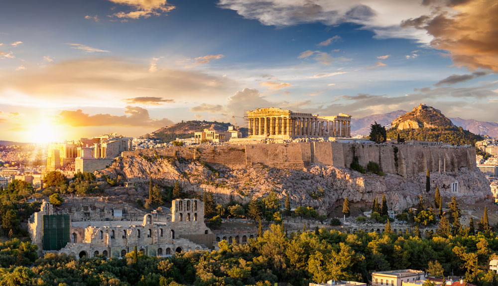 the acropolis of athens greece with the parthenon temple on top of the hill during a summer sunset